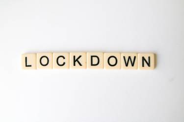Cream coloured square tiles with black letters spelling the word "Lockdown"
