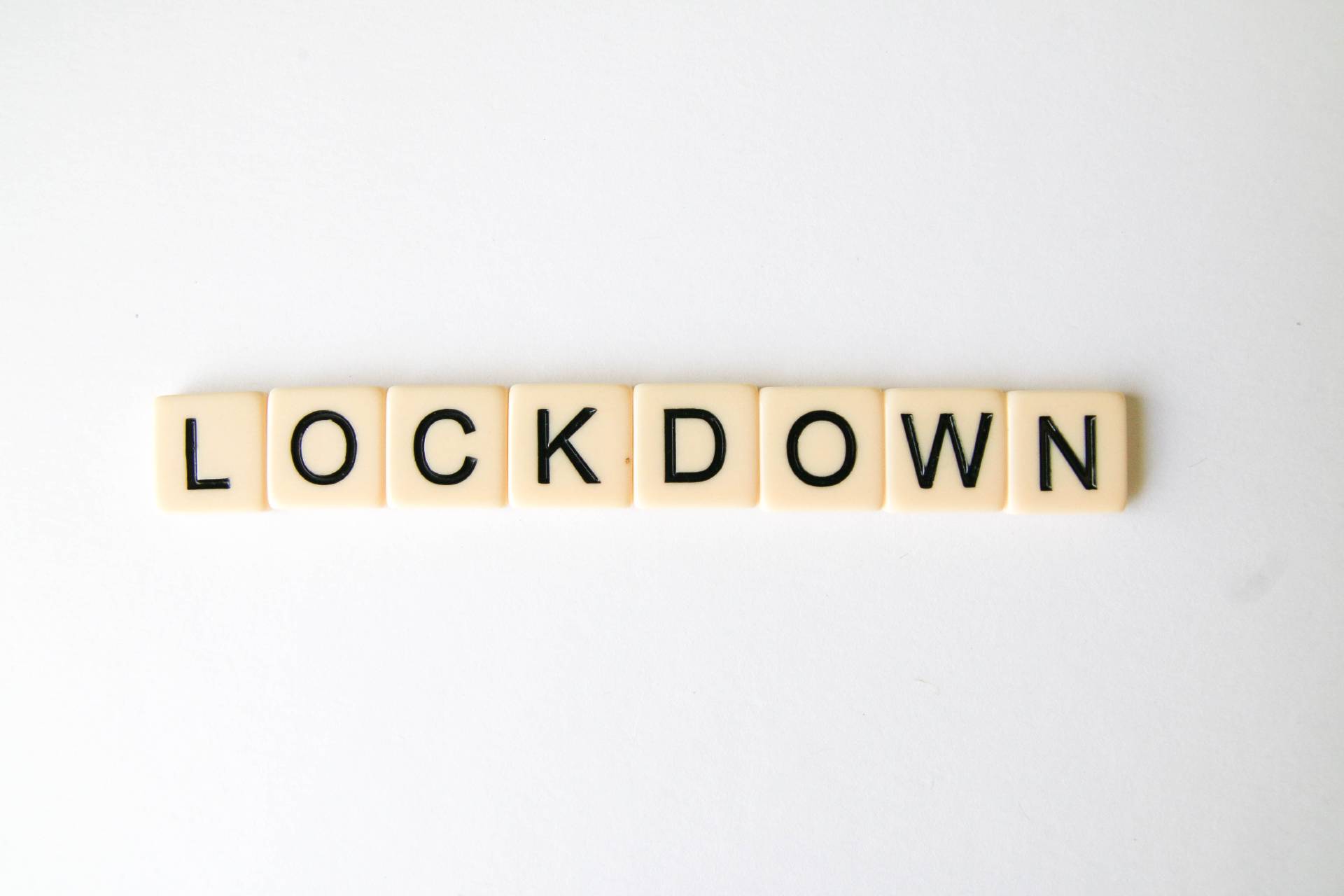 Cream coloured square tiles with black letters spelling the word "Lockdown"