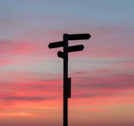 Signpost with four different signs pointing in four directions